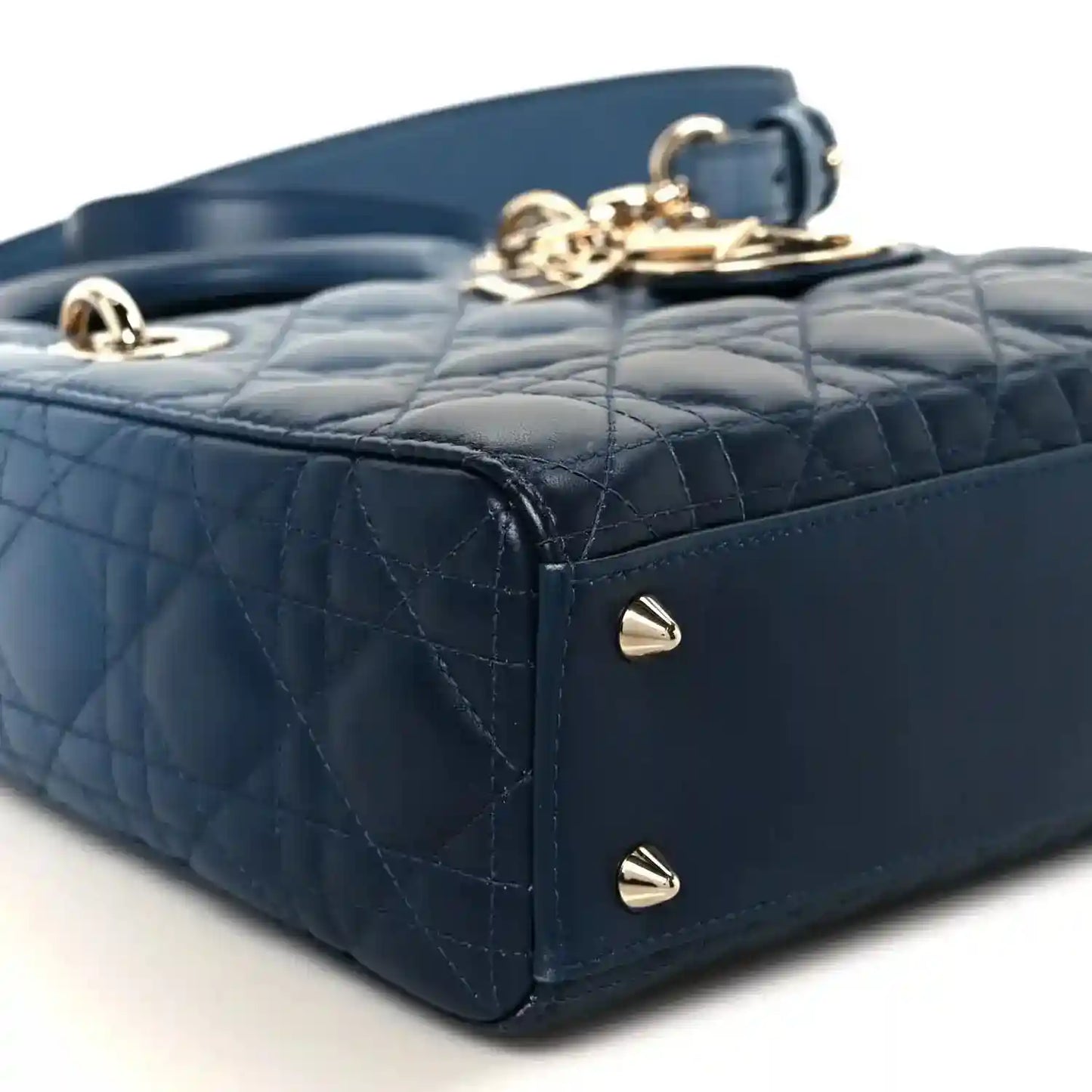 Small indigo blue quilted leather handbag corner with gold studs and top clasp