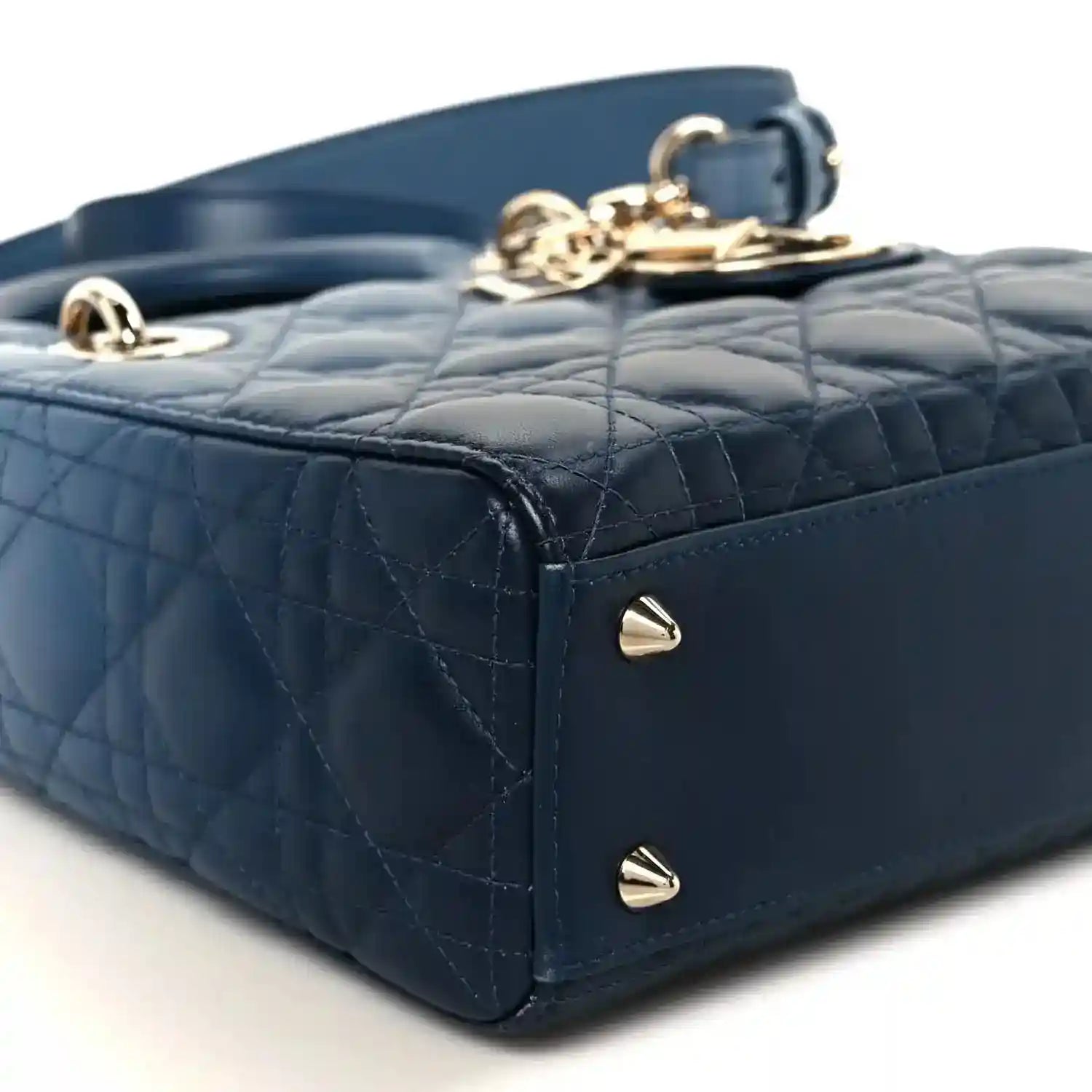 Small indigo blue quilted leather handbag corner with gold studs and top clasp
