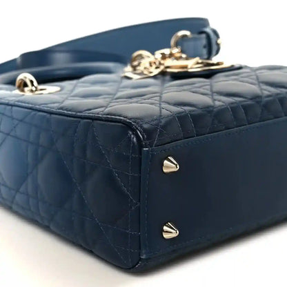 Small indigo blue quilted leather handbag corner with gold studs and top clasp