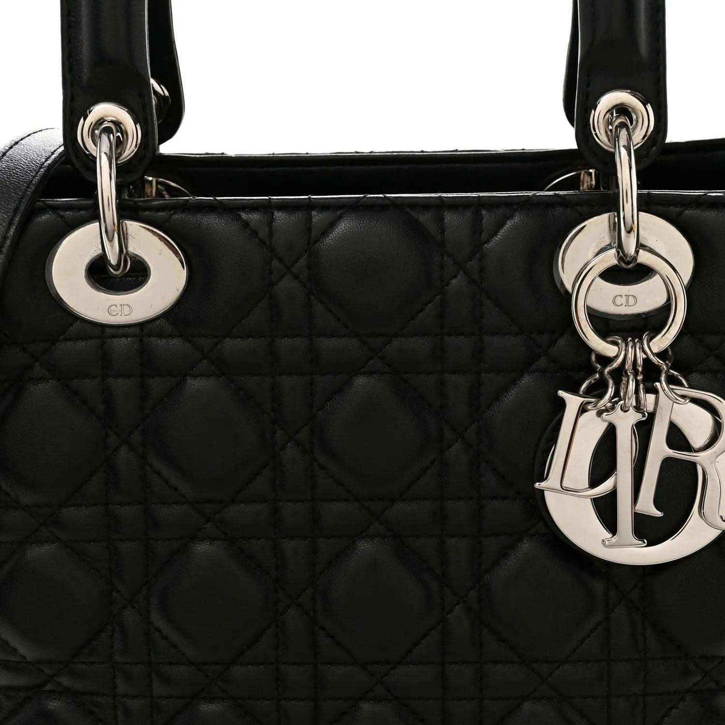 Lady Dior handbag front close-up: quilted black leather with CD ring handles and charm