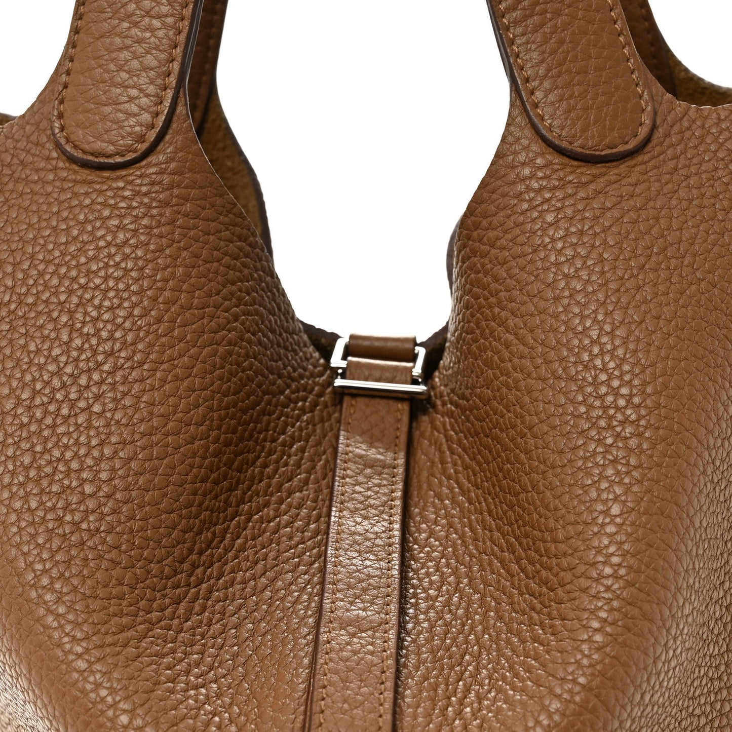 Tan leather tote front close-up with lock bar and zipper, textured grain