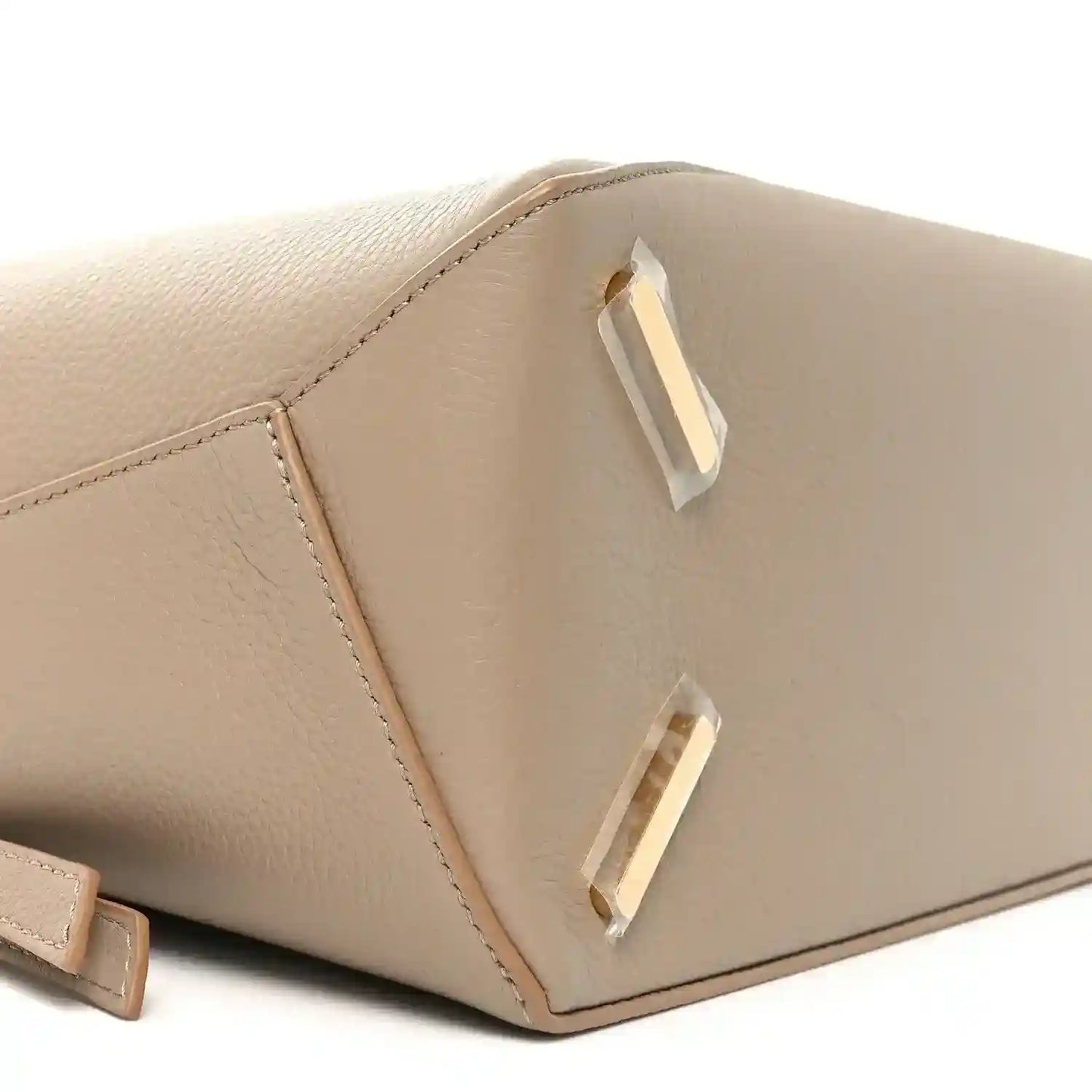 Sand leather puzzle edge bag side view with gold-tone buckle detail and stitched seams.