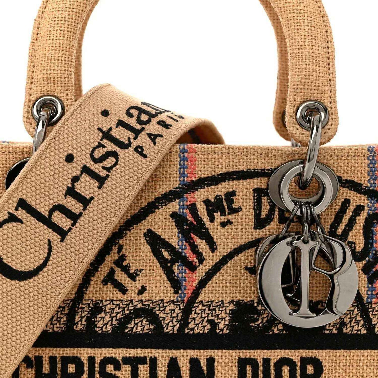 Jute canvas bag front with embroidered letters and metal Dior charm on ring.