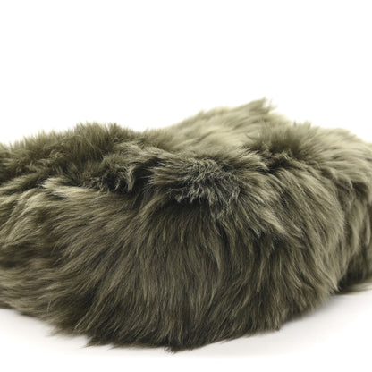 Dark olive shearling bag with dense textured fur and curved seam detail