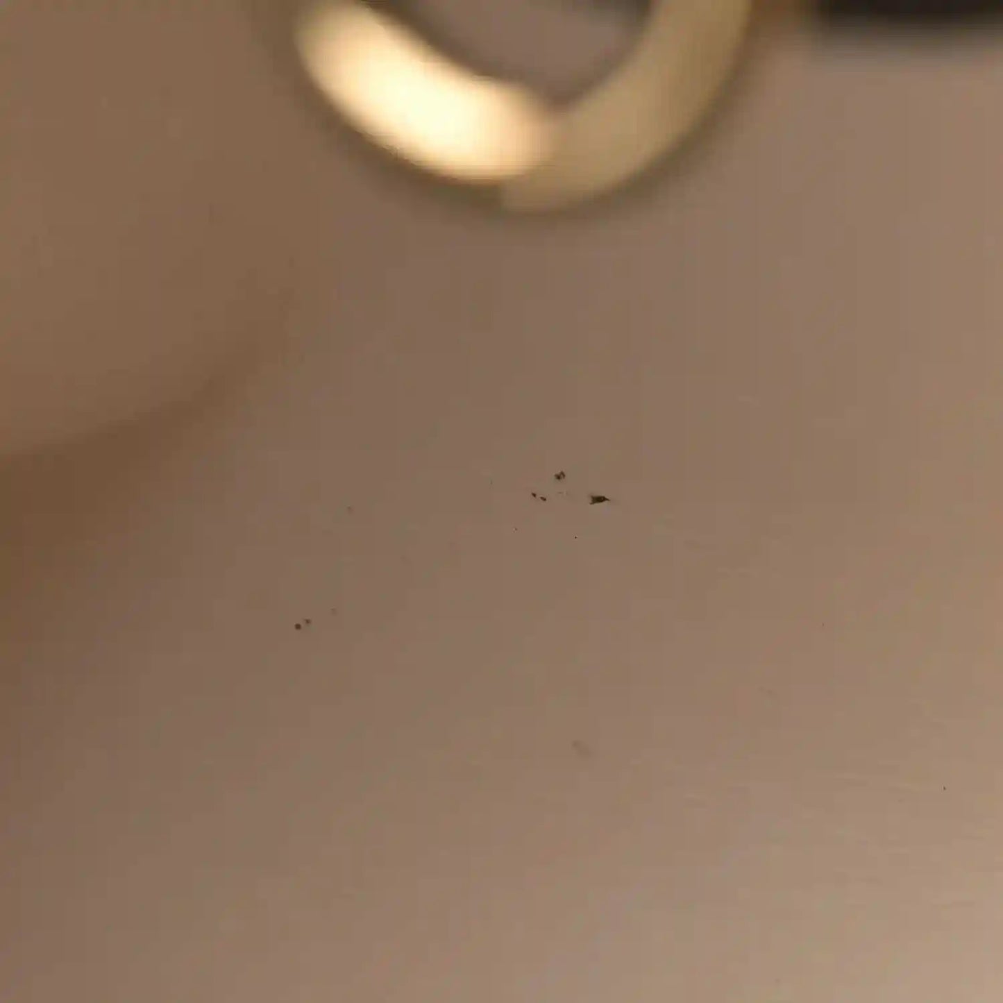 Blurry close-up of gold-toned hardware on a black leather bag