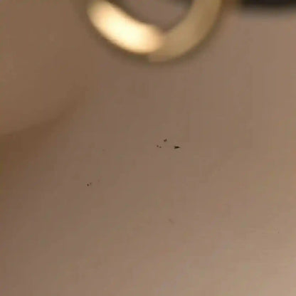 Blurry close-up of gold-toned hardware on a black leather bag