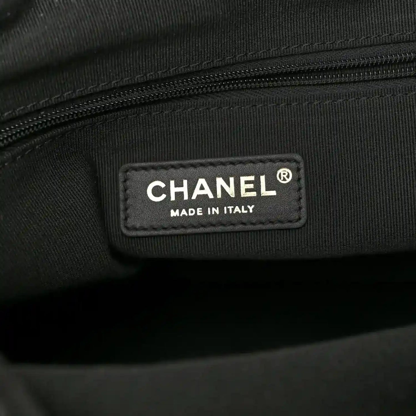Chanel fabric label on shopping bag lining reading “CHANEL” and “MADE IN ITALY”