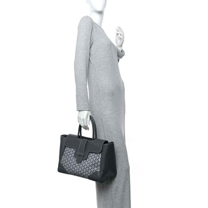 Grey leather-trimmed tote worn by model, patterned canvas front and top handles