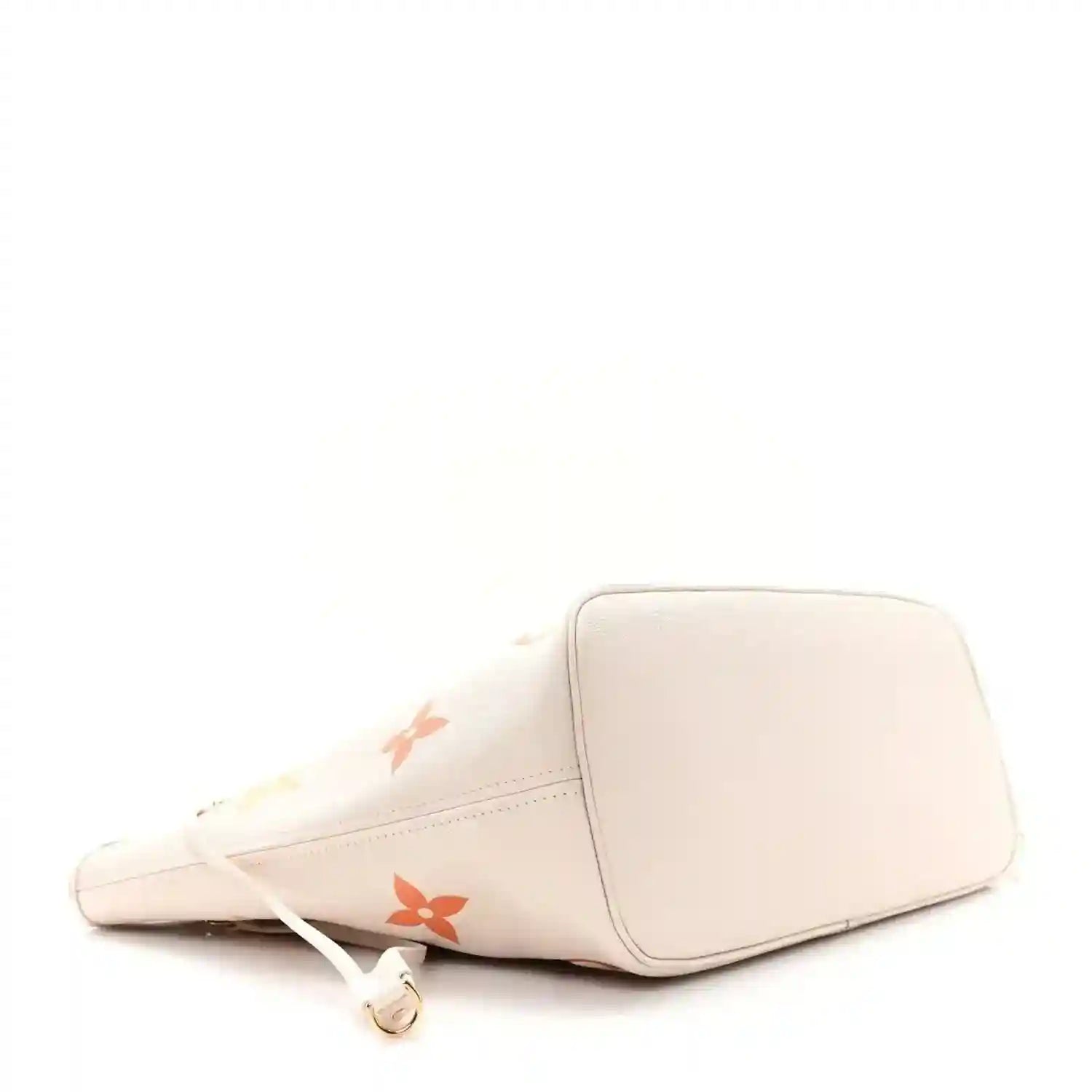 Neutral tote bag with monogram accents and top zipper pull, side view