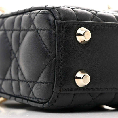 Black quilted micro handbag side with gold-tone stud hardware and stitching