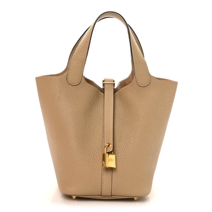 Beige leather tote bag with top handles and gold lock closure hardware