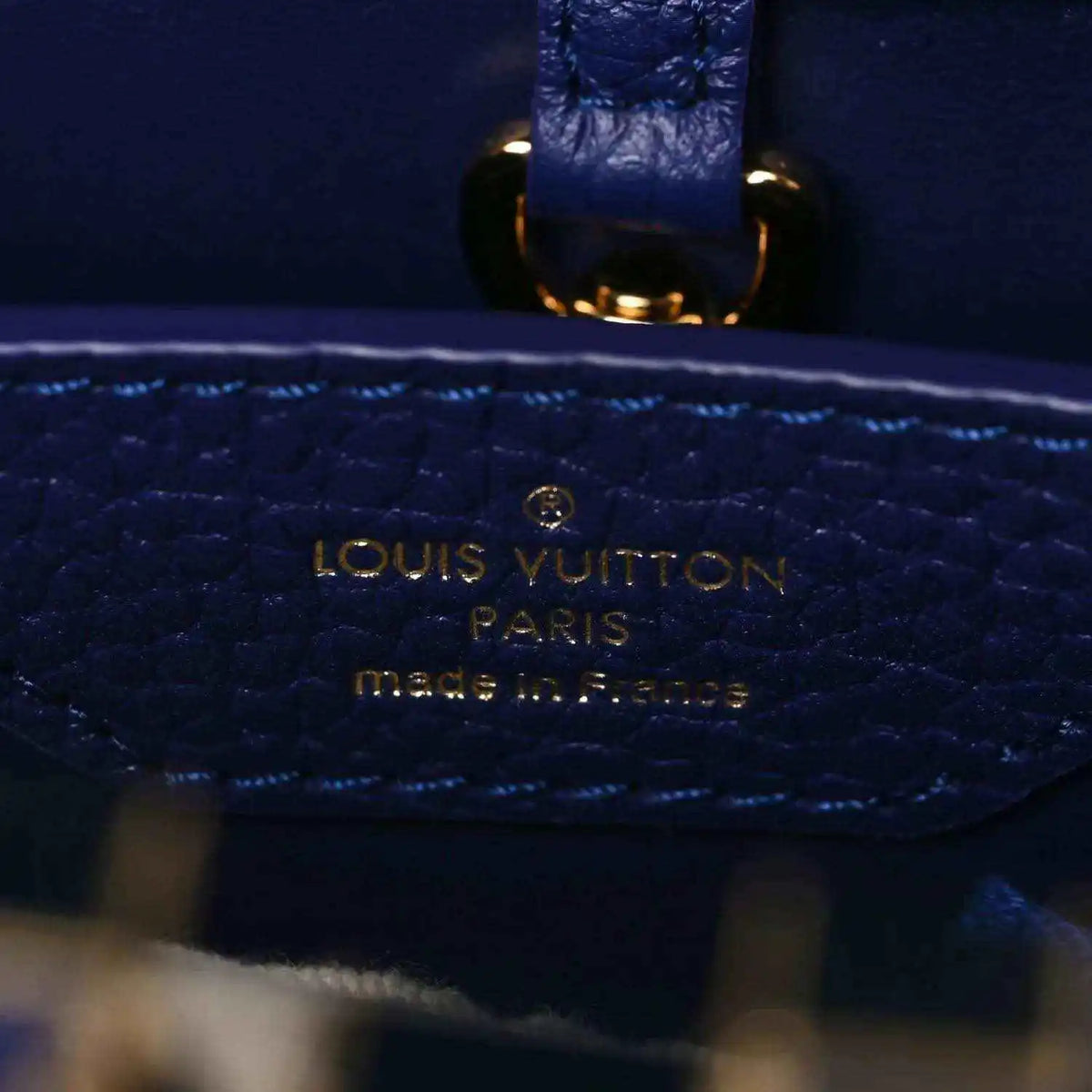 Close-up of Louis Vuitton stamped pocket on dark blue pebbled leather