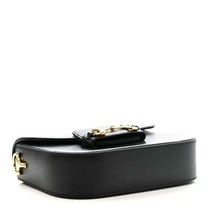 Black leather mini bag with gold-tone horsebit hardware and curved flap top