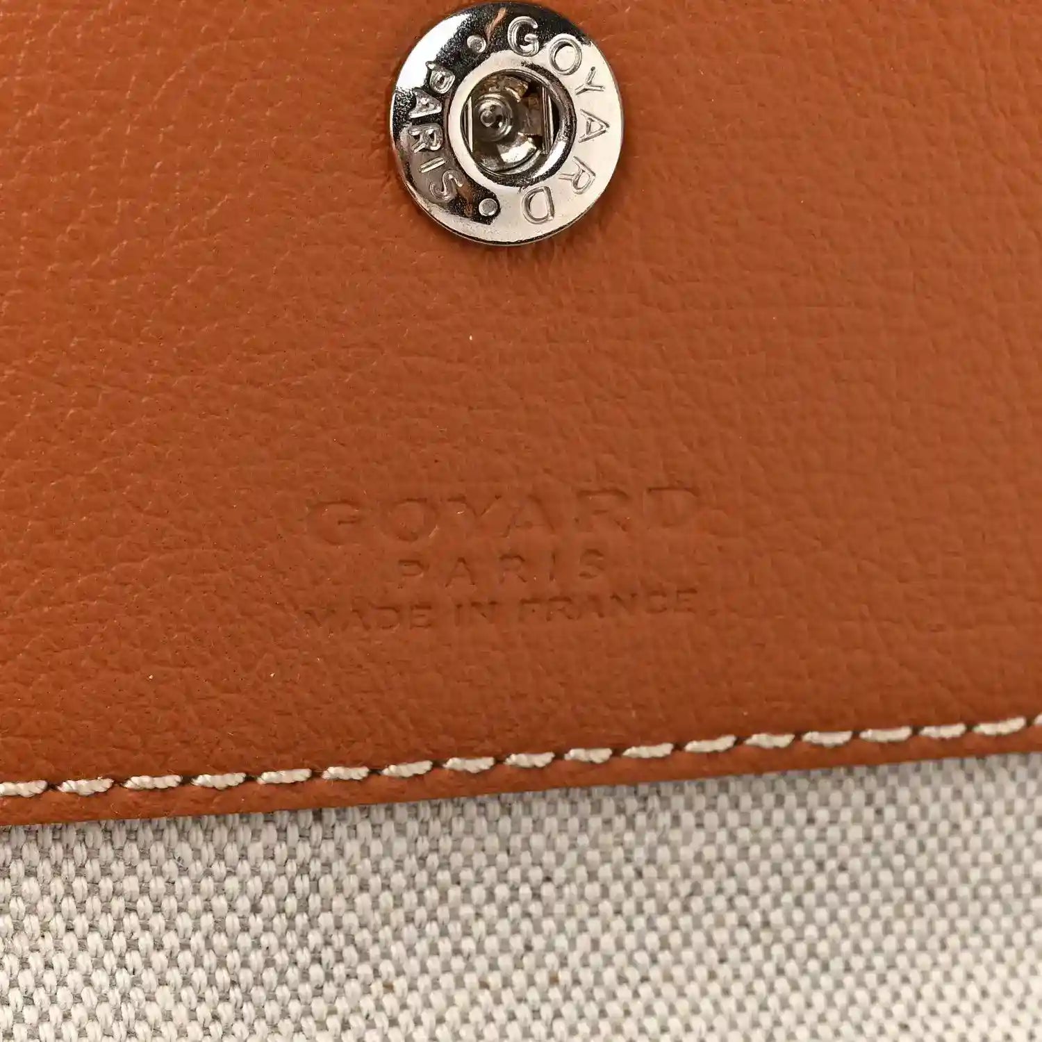 Goyard hobo bag close-up of metal snap on tan leather trim