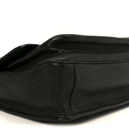 Black grained leather satchel with curved flap seam and smooth leather panels