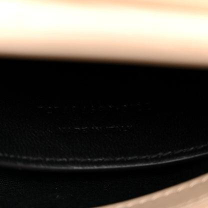 Dark leather interior seam close-up with stitched edge and gold chain attachment