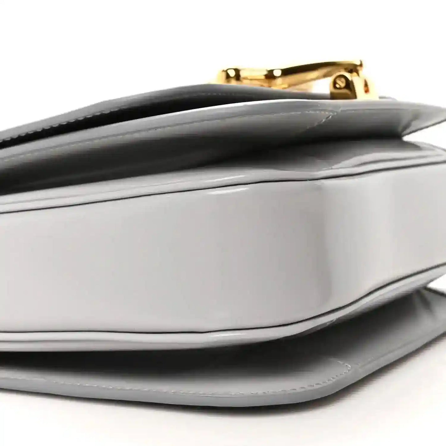Light grey bag flap and top edge with gold-tone clasp and smooth structured sides