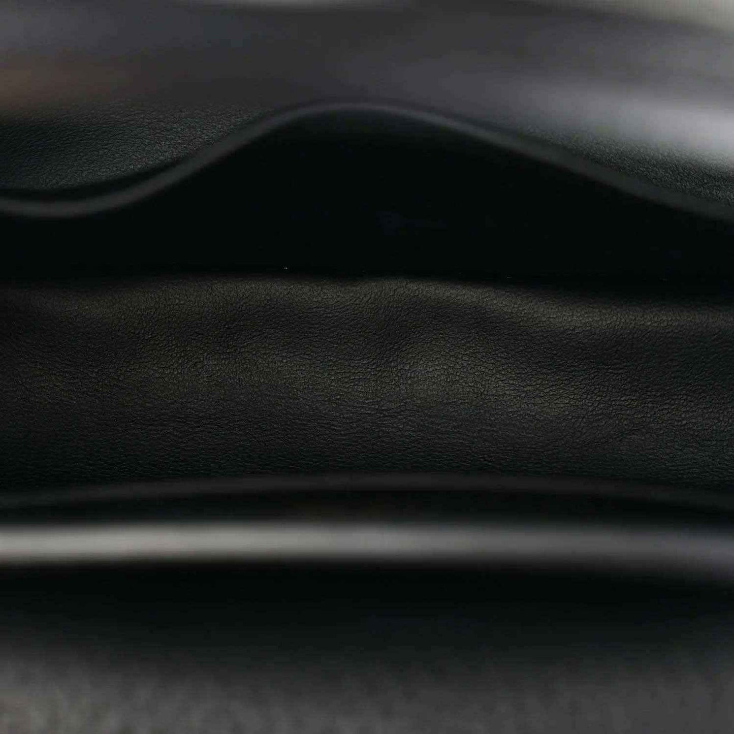 Black leather mini handbag close-up of stitching and embossed texture