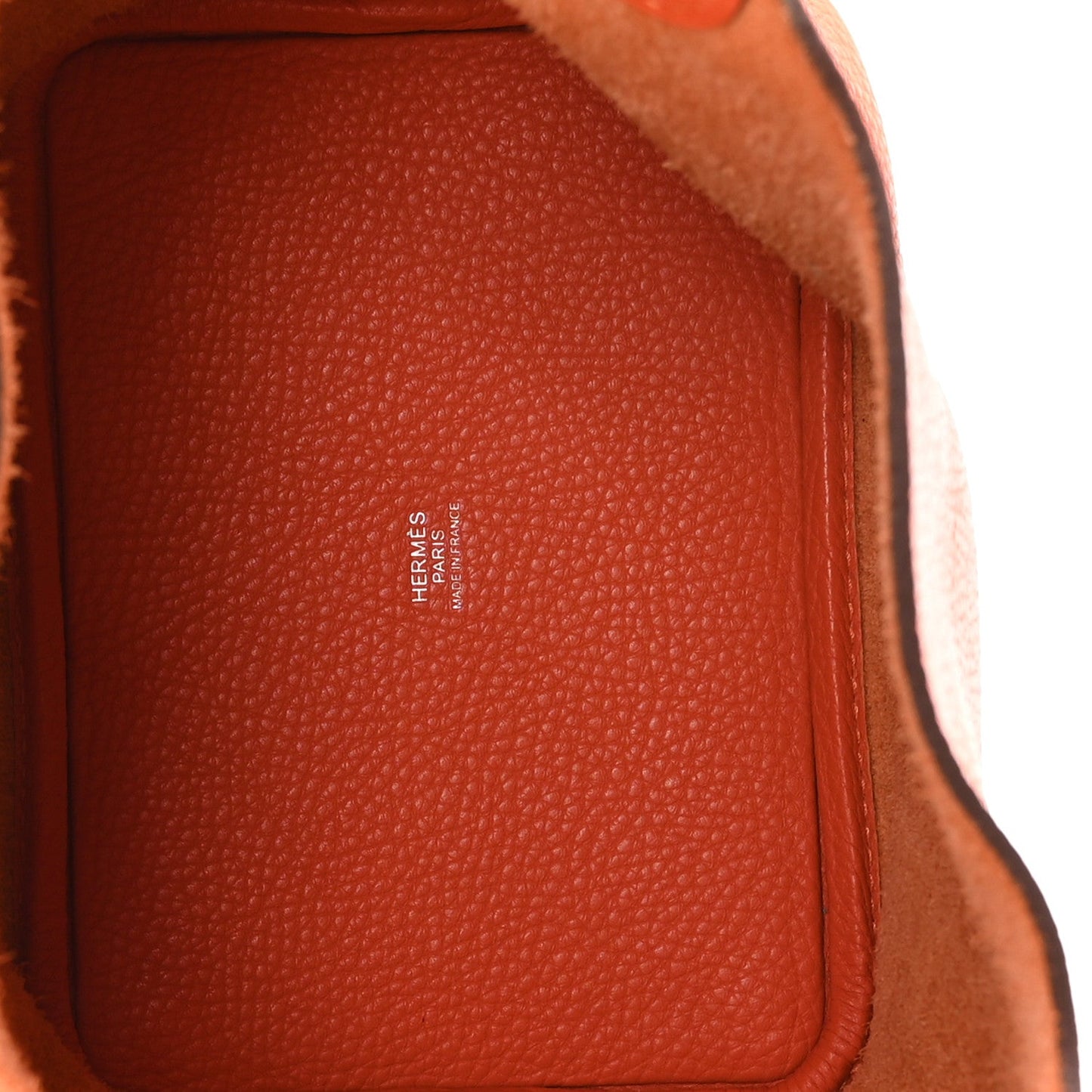 Orange pebbled leather handbag interior panel with stitched edge detail
