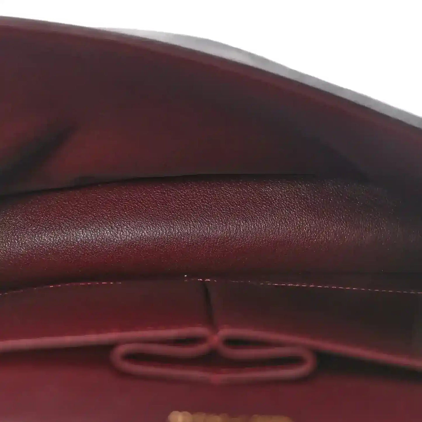 Leather interior seam with decorative pull tab inside the bag