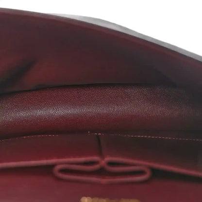 Leather interior seam with decorative pull tab inside the bag