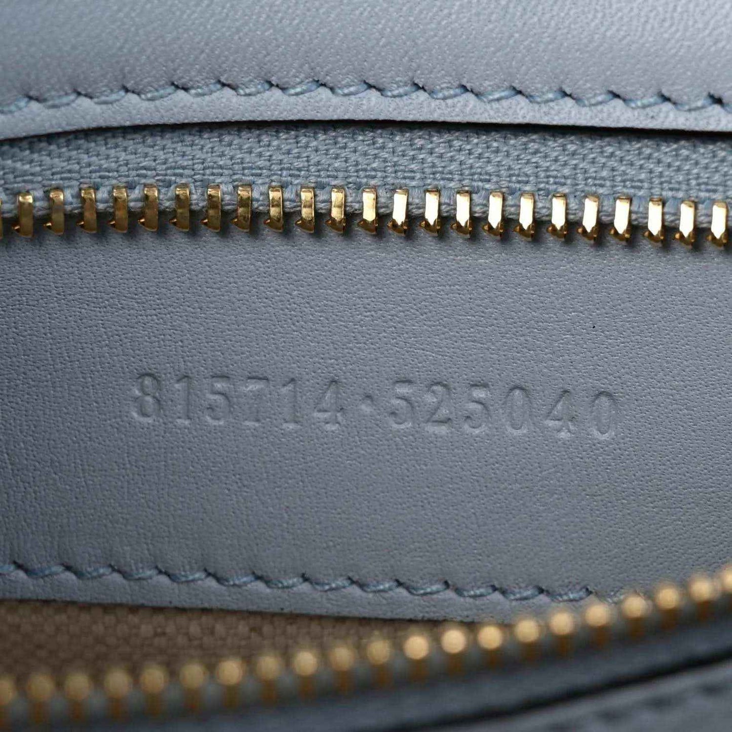 Light blue calfskin lining with gold zipper teeth and embossed code