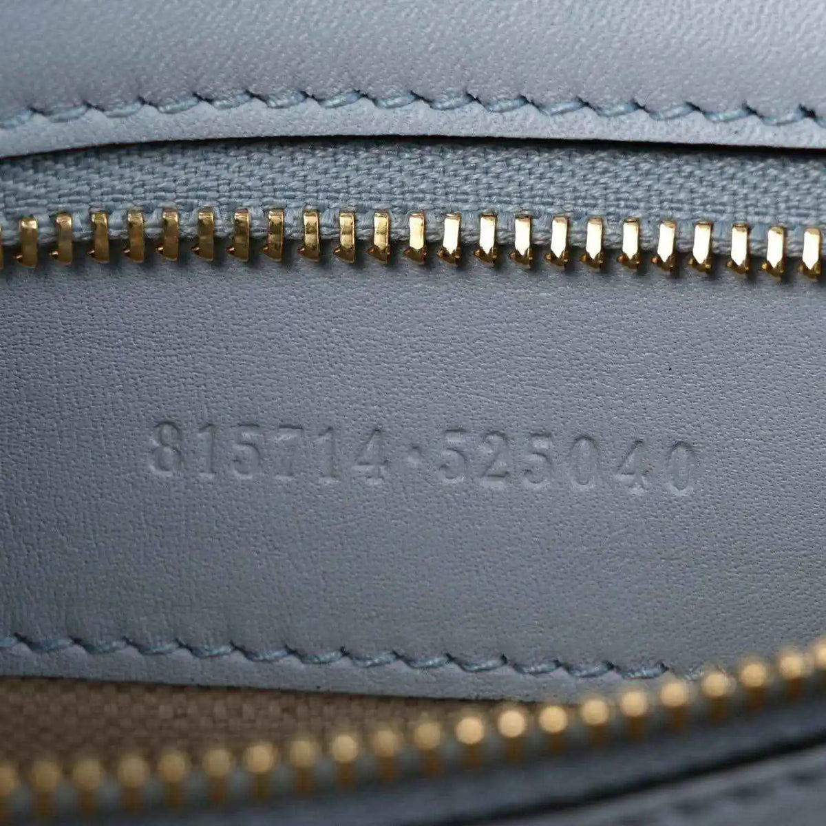 Light blue calfskin lining with gold zipper teeth and embossed code