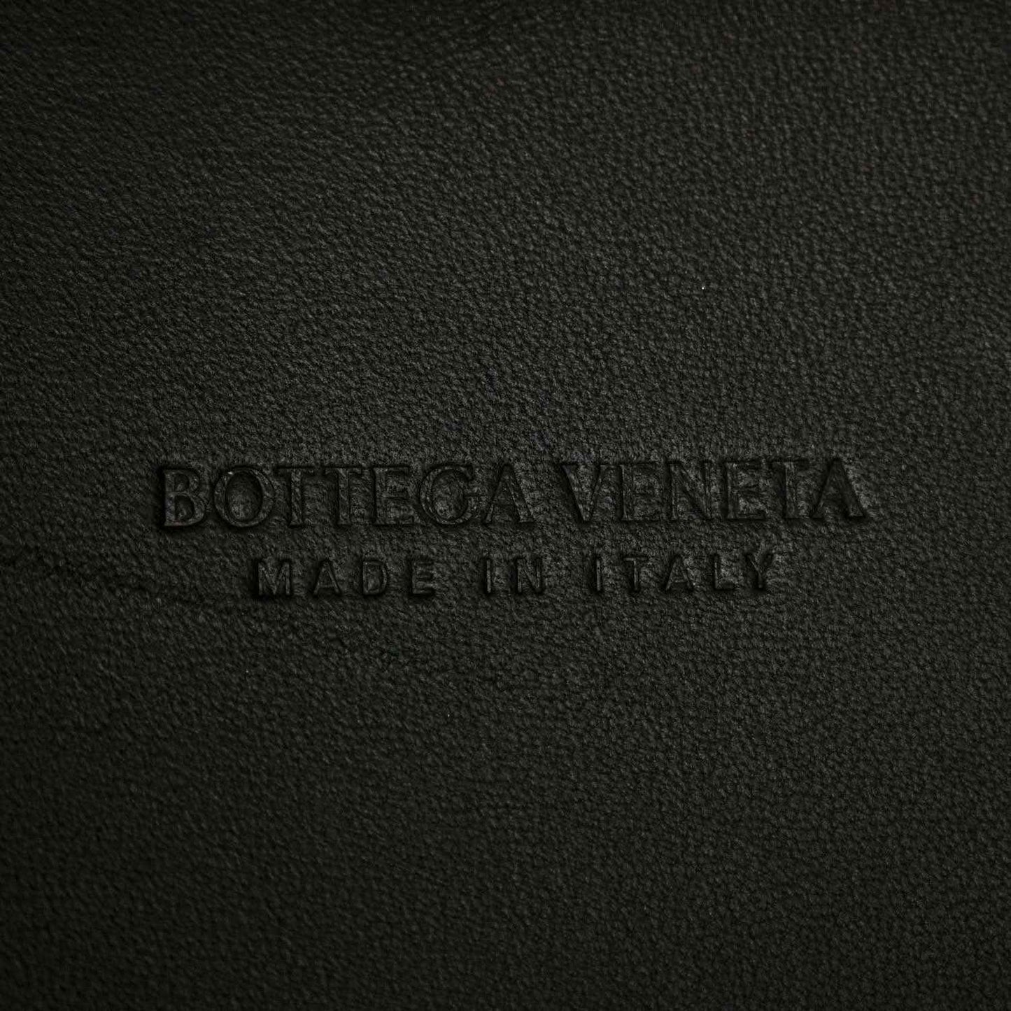 Black leather bag interior label text embossed on fabric surface