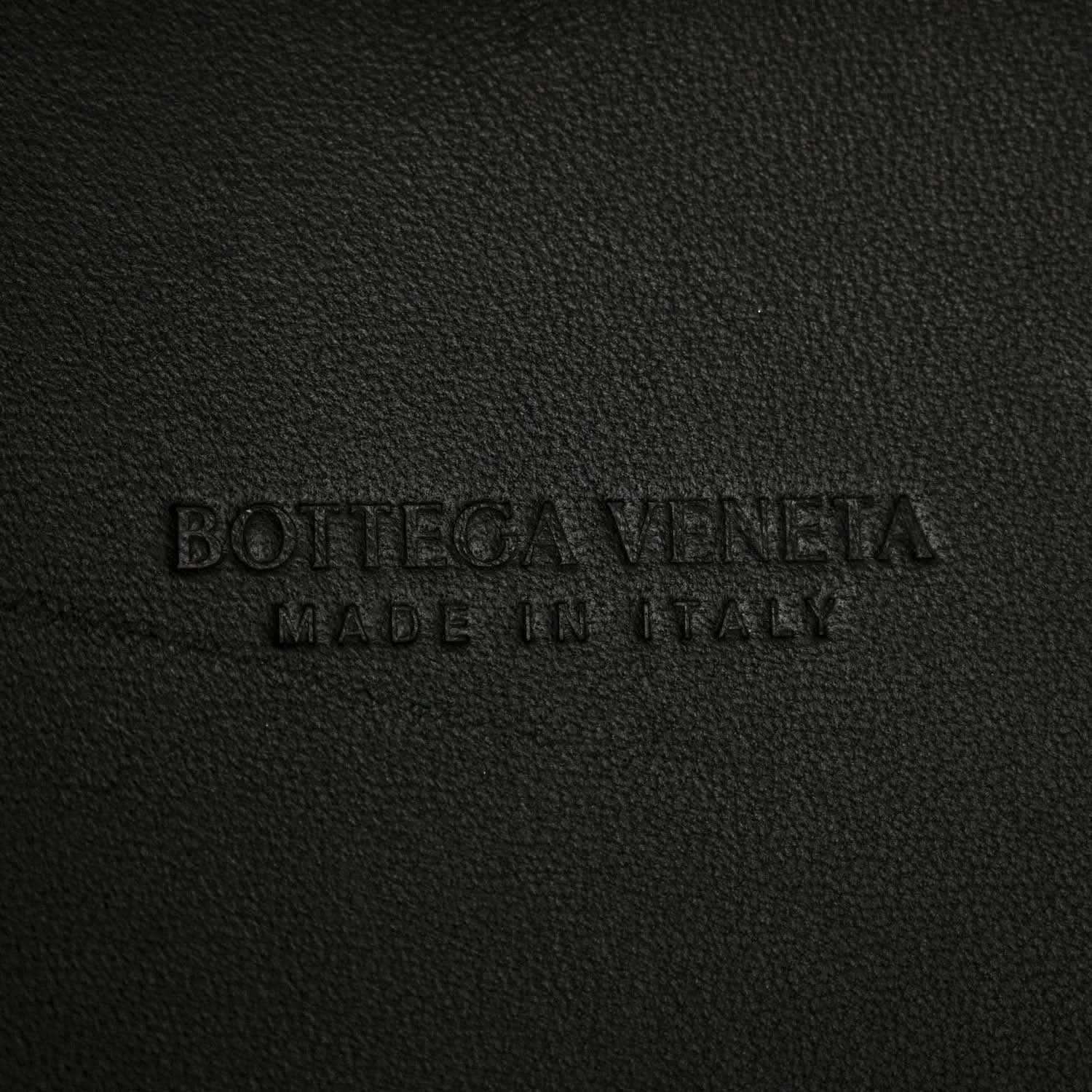 Black leather bag interior label text embossed on fabric surface