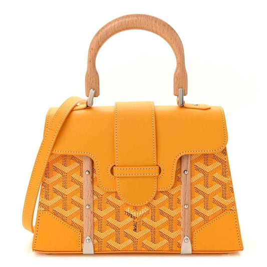 Yellow canvas handbag with top handles, shoulder strap, and patterned front panels.