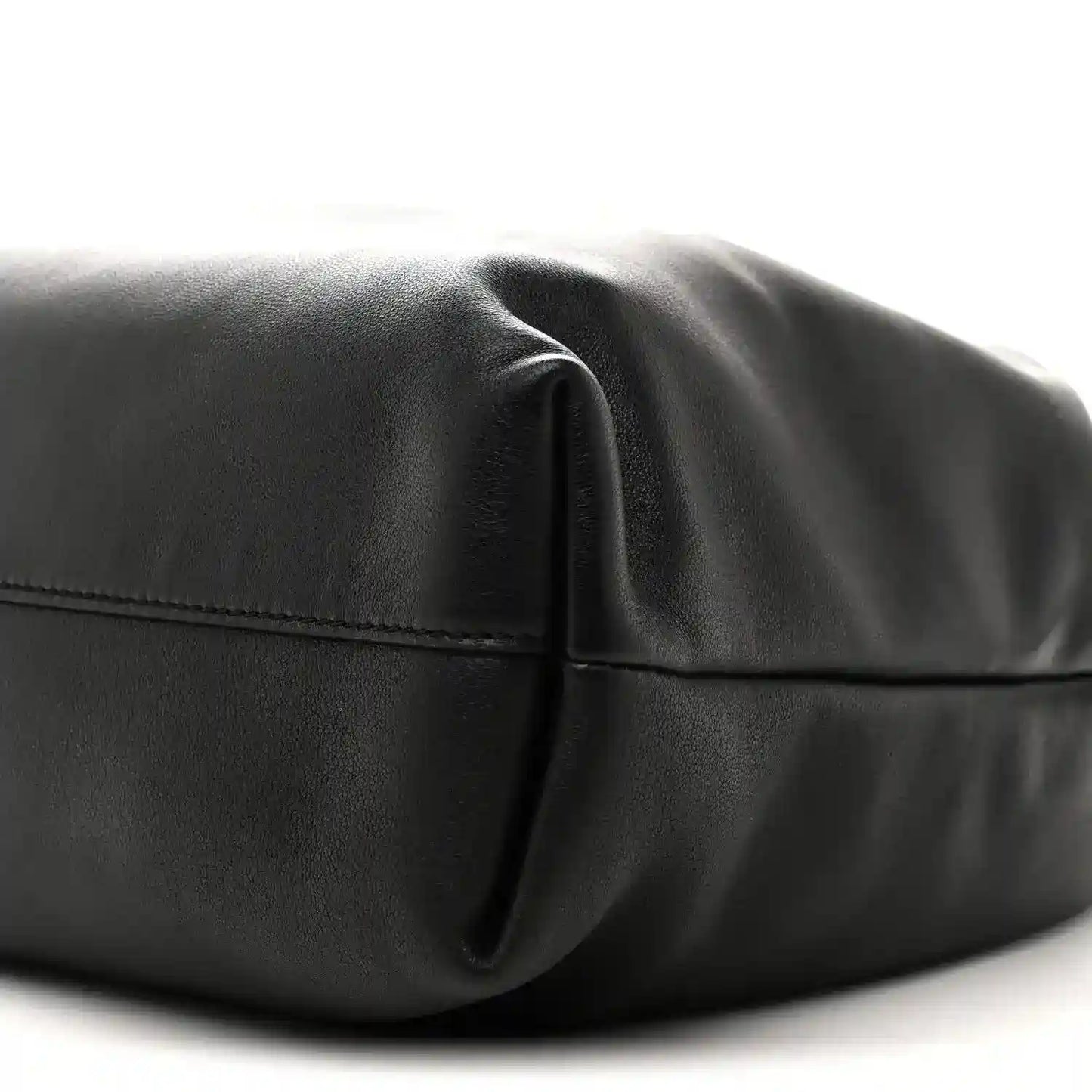 Black leather bag close-up of curved front seam and leather panel