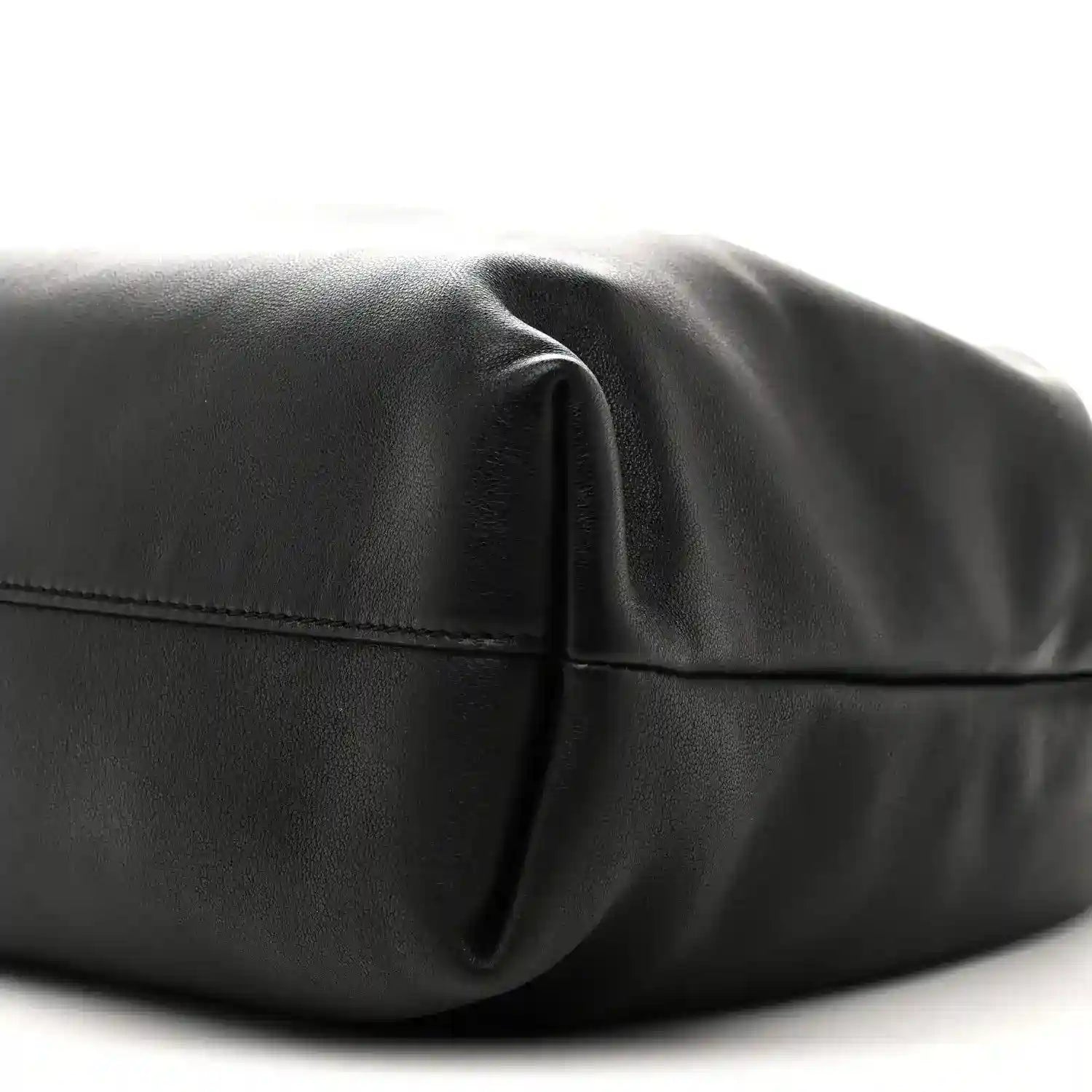 Black leather bag close-up of curved front seam and leather panel