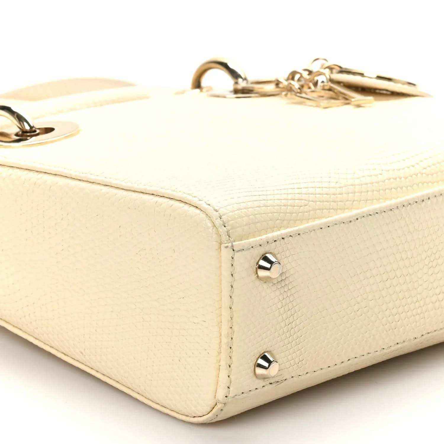 Ivory lizard mini handbag side view with gold corner studs and zipper hardware