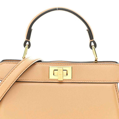 Small satchel top handle with gold-tone logo clasp on beige leather body