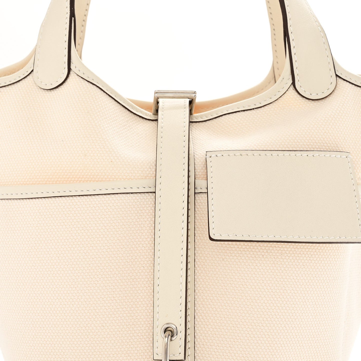 Nata canvas tote with top handles, front pocket, and center zipper hardware