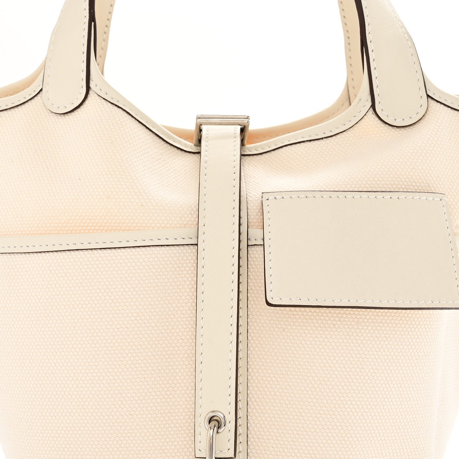 Nata canvas tote with top handles, front pocket, and center zipper hardware