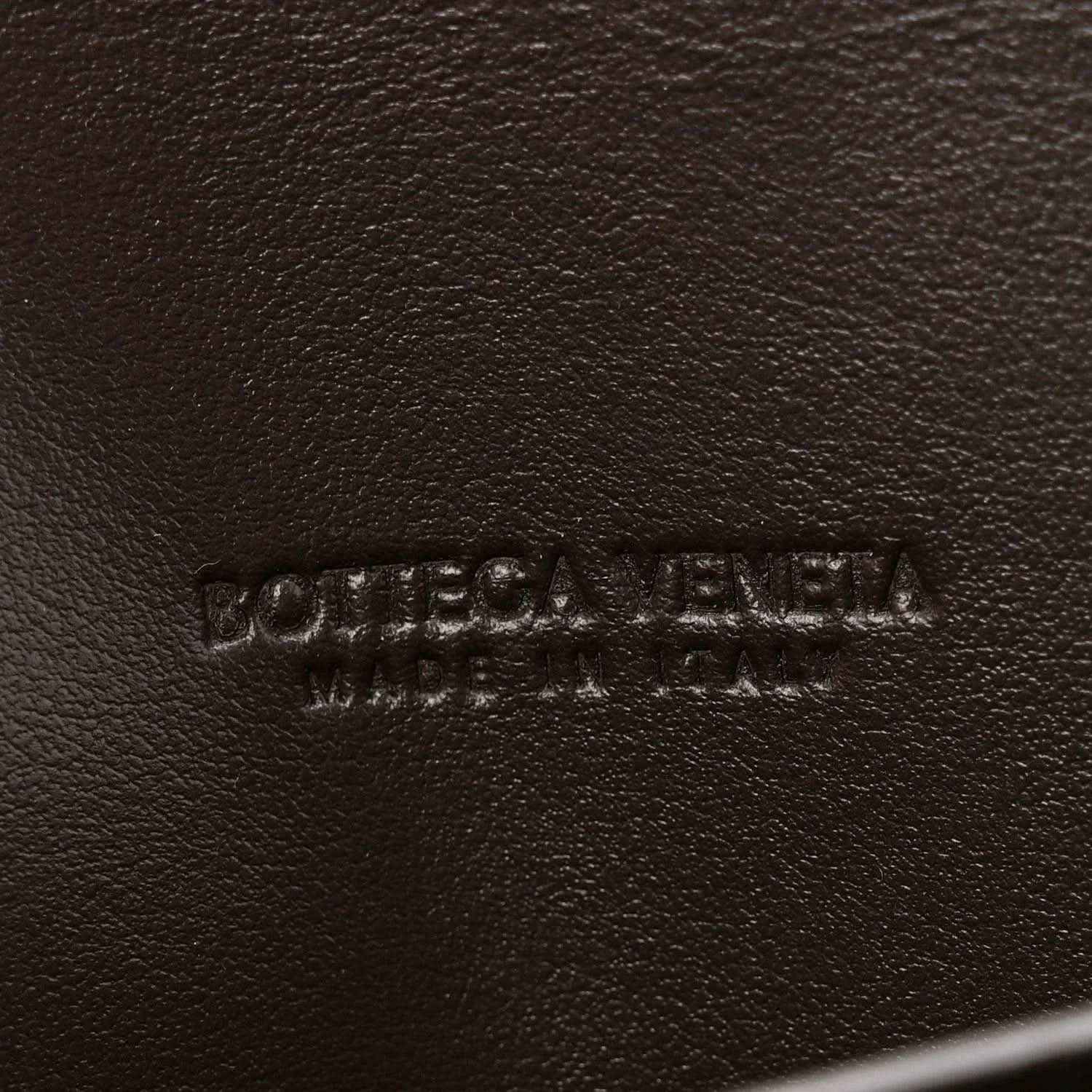Bottega Veneta embossed leather clutch exterior in dark tone