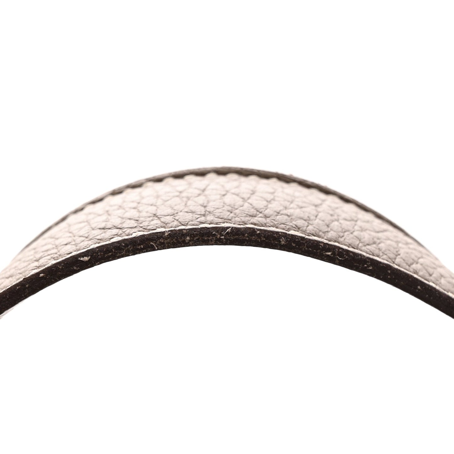 Taupe calfskin leather bag handle close-up, textured grain and dark trim