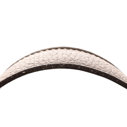 Taupe calfskin leather bag handle close-up, textured grain and dark trim