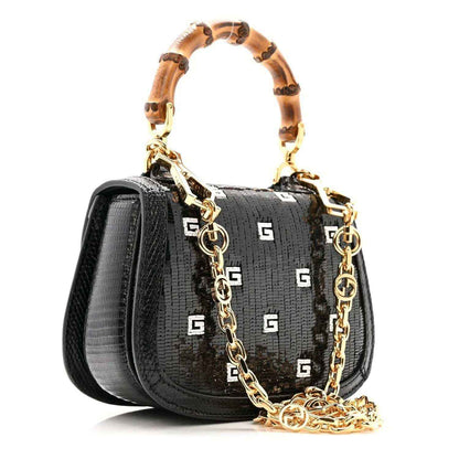 Black mini top handle bag with GG motif, gold chain strap, and bamboo handle accents