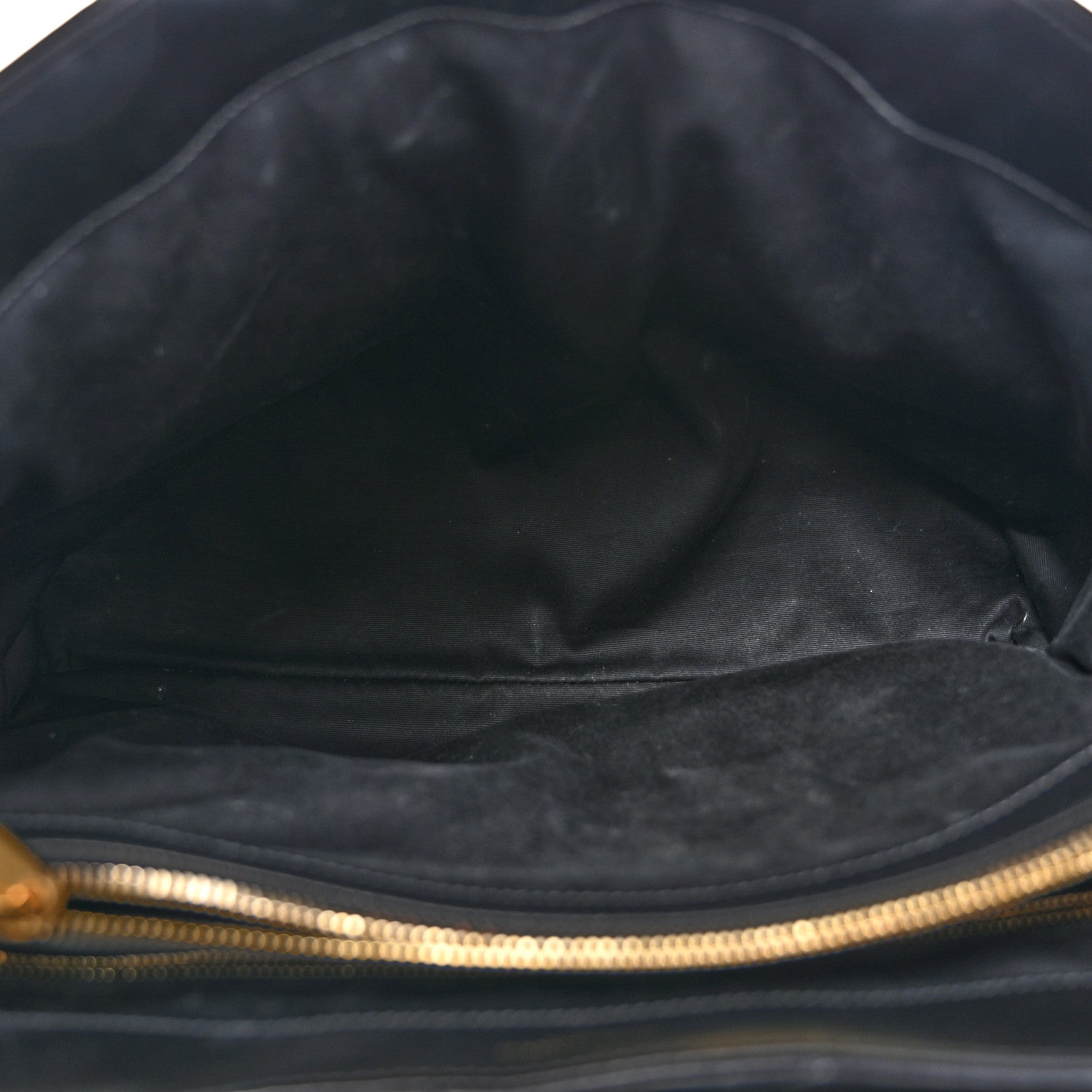 Black satchel interior with fabric lining and gold-tone zipper trim