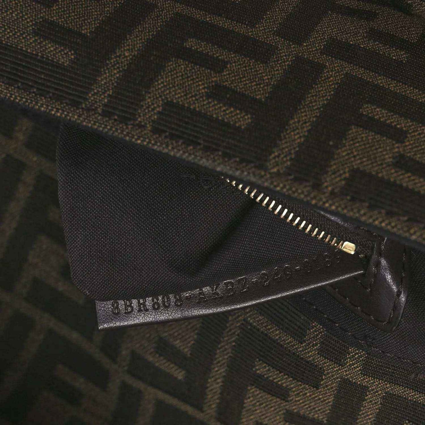 Fendi FF jacquard bag close-up of zipper and brand tab on dark brown fabric
