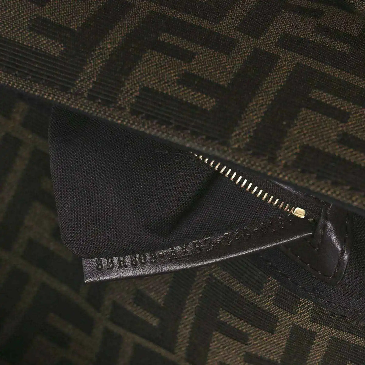 Fendi FF jacquard bag close-up of zipper and brand tab on dark brown fabric