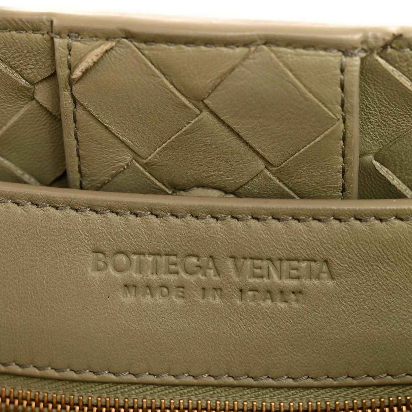 Leather interior panel with embossed logo, woven nappa texture in light tan
