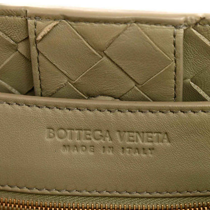 Leather interior panel with embossed logo, woven nappa texture in light tan