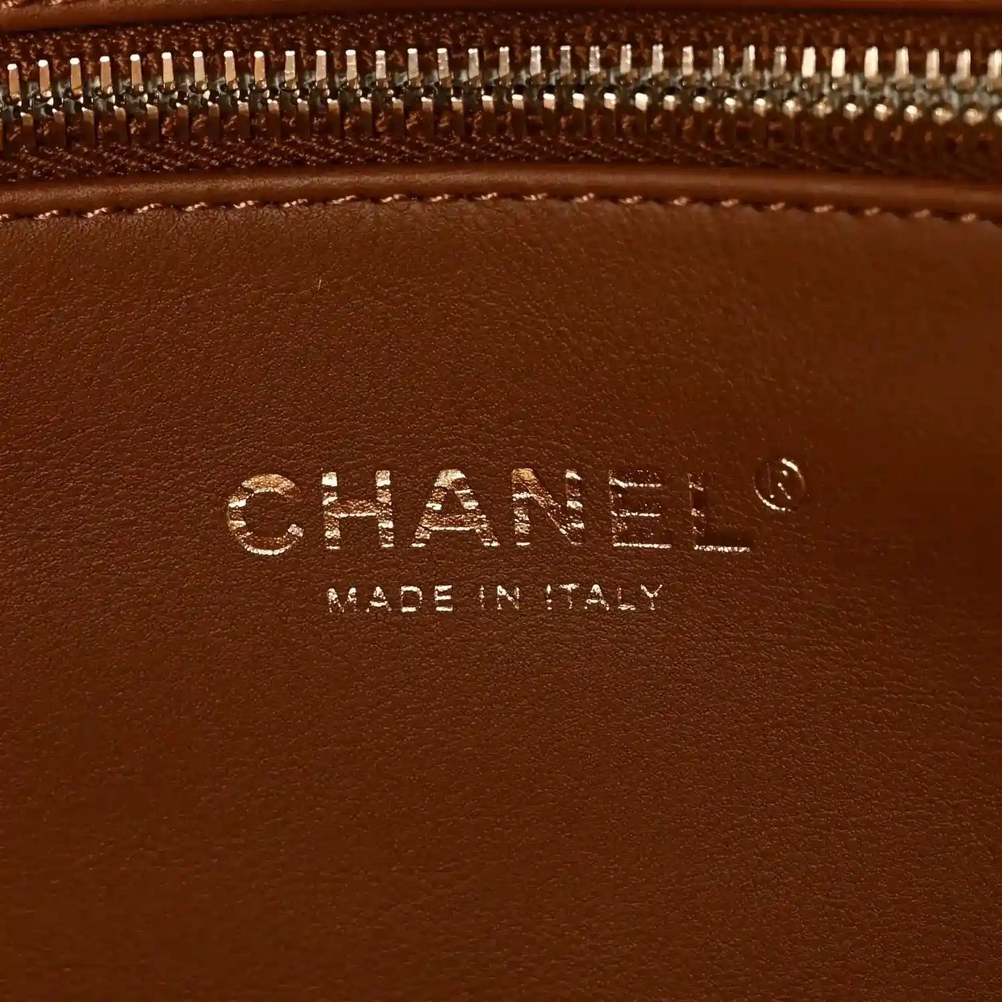 Chanel logo detail on brown leather tote, with text 'Made in Italy'
