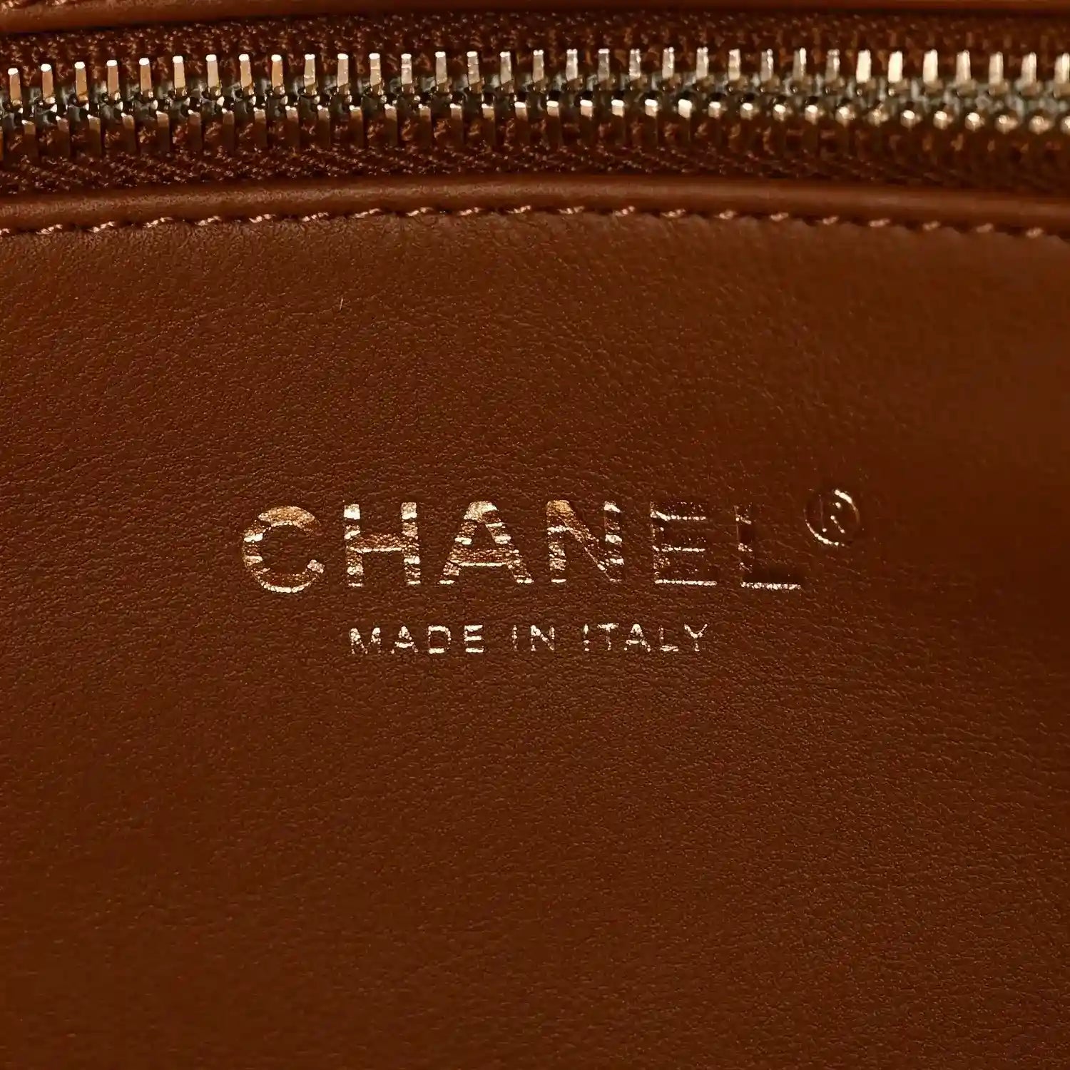 Chanel logo detail on brown leather tote, with text 'Made in Italy'