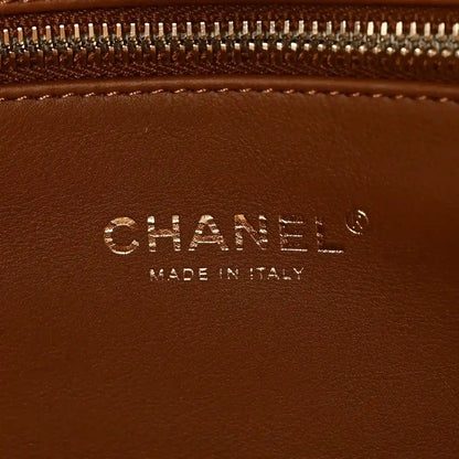 Chanel logo detail on brown leather tote, with text 'Made in Italy'