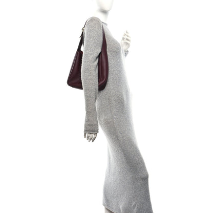 Burgundy leather hobo bag with short top handle, shown on a mannequin