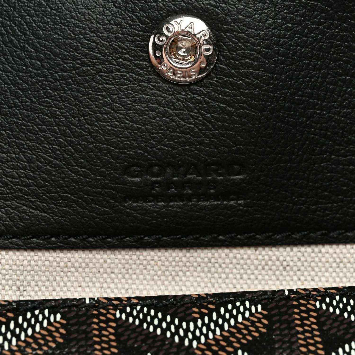 Goyard logo button and embossed leather patch on black tote bag